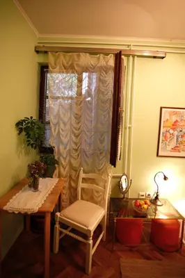 a table and a chair in a room with a window at Studio Hram 2 in Belgrade
