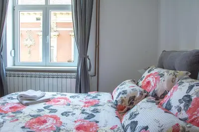 a bed with a floral blanket and a window at Apartment Petra 072 in Belgrade
