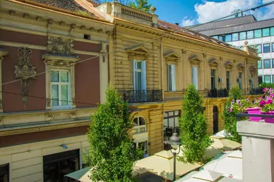 a yellow building with trees in front of it at Apartment Petra 072 in Belgrade