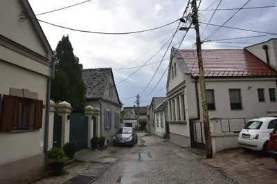 an alley with houses and a car parked on a street at Beograd - apartman 