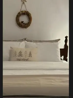 a bed with white pillows and a mirror on the wall at Principessa Apartment in Belgrade