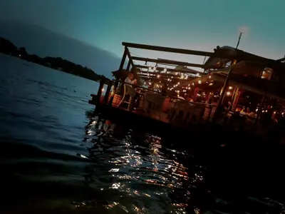 a boat with lights on the water at night at Principessa Apartment in Belgrade