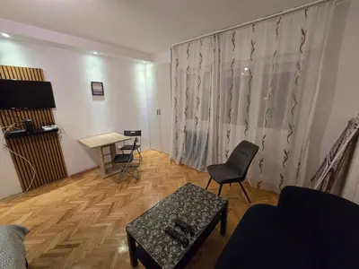 a living room with a chair and a table at Azzurro Studio Apartment in Belgrade