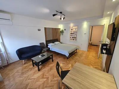 a hotel room with a bed and a table at Azzurro Studio Apartment in Belgrade