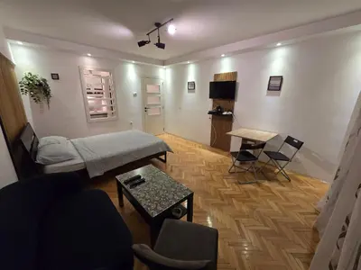 a living room with a couch and a table at Azzurro Studio Apartment in Belgrade