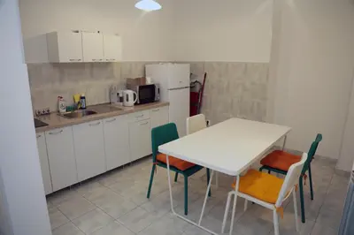 a kitchen with a table and chairs and a refrigerator at Petars Apartment in Belgrade