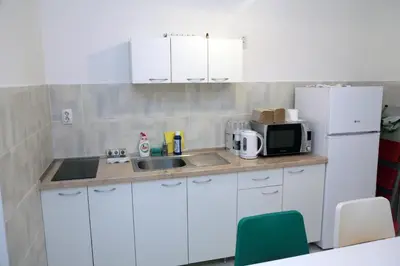 a kitchen with white cabinets and a sink and a microwave at Petars Apartment in Belgrade
