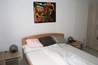 a bedroom with a bed with a painting on the wall at Petars Apartment in Belgrade