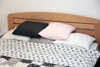 a bed with three pillows on top of it at Petars Apartment in Belgrade