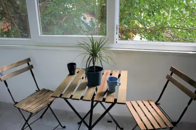 a wooden table with two chairs and a potted plant on it at King Marko Apartment (65m2) in Belgrade