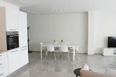 a kitchen and dining room with a table and chairs at Lux House Olga in Ruma