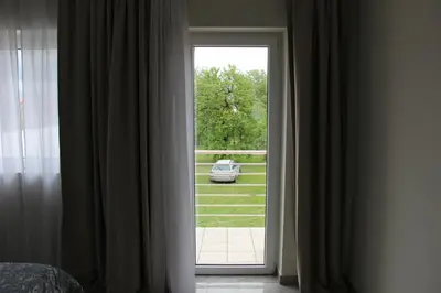 a door to a bedroom with a car outside at Lux House Olga in Ruma