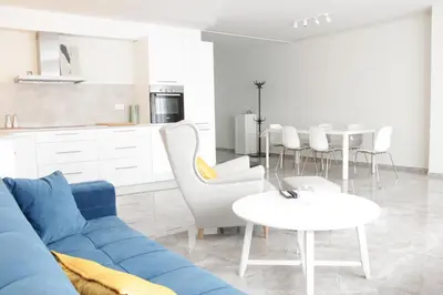 a living room with a blue couch and a table at Lux House Olga in Ruma