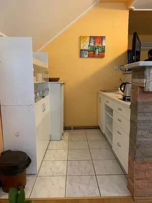 a kitchen with white appliances and a yellow wall at Bellmatini in Belgrade