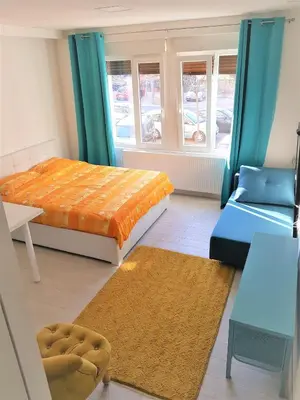 a bedroom with a bed and a couch and a chair at Asya Studio in Belgrade