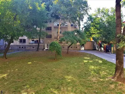 a building with trees in front of a yard at Asya Studio in Belgrade