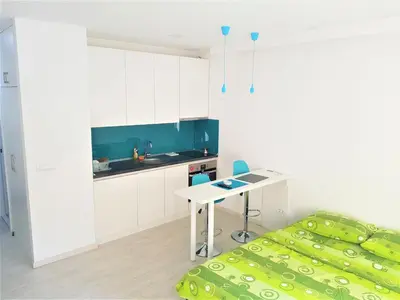 a kitchen with a table and a bed in a room at Asya Studio in Belgrade