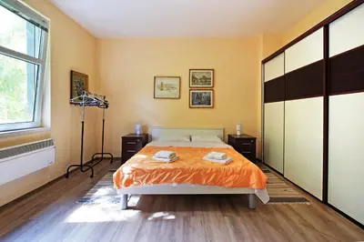 a bedroom with a bed with orange sheets and a window at Apartment Paradise Sunny Home in Belgrade