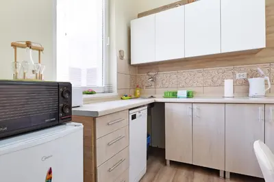 a kitchen with white cabinets and a microwave at Apartment Paradise Sunny Home in Belgrade