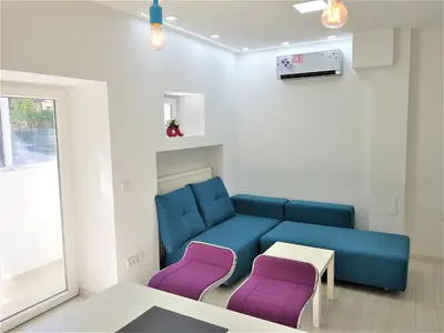 a living room with a blue couch and purple chairs at Asya Blue Apartment in Belgrade