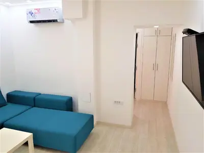 a living room with a blue couch and a door at Asya Blue Apartment in Belgrade