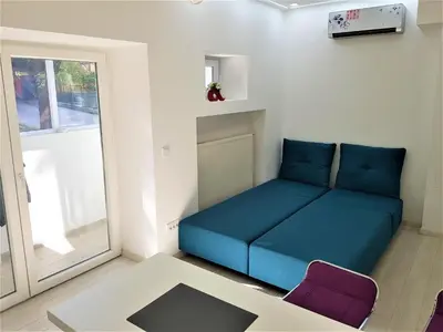 a living room with a blue couch and a window at Asya Blue Apartment in Belgrade