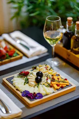 a plate of food on a table with a glass of wine at Boutique Hotel Museum in Belgrade