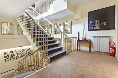 a spiral staircase in a house with a sign on the wall at SuperB Luxury Suites in Belgrade
