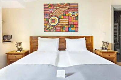 a bedroom with a bed with a painting above it at SuperB Luxury Suites in Belgrade