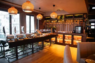 a restaurant with a long table with food on it at Amsterdam Hotel in Belgrade