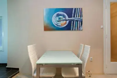a table and chairs in a room with a painting at Central Apartments in Belgrade