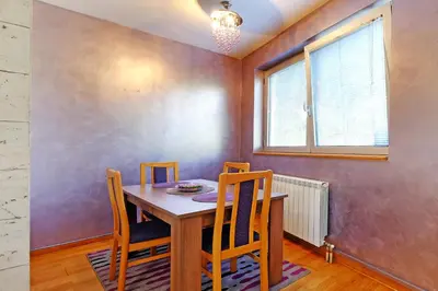 a dining room with a wooden table and chairs at Apartment Paradise Symphony in Belgrade