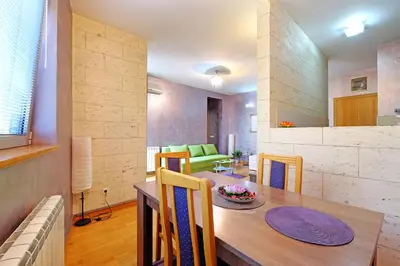 a dining room and living room with a table and chairs at Apartment Paradise Symphony in Belgrade