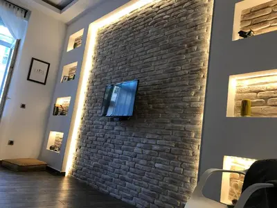 a tv on a brick wall in a room at Al Mattina Apartments Belgrade in Belgrade