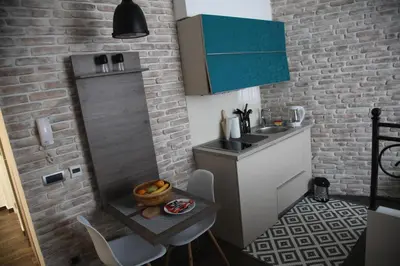 a kitchen with a sink and a brick wall at Al Mattina Apartments Belgrade in Belgrade