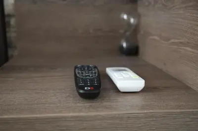 two remote controls sitting on top of a drawer at Al Mattina Apartments Belgrade in Belgrade