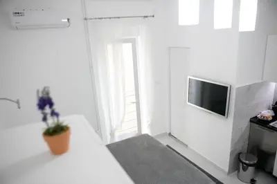 a small white room with a television and a door at Natalie's Studio in Belgrade