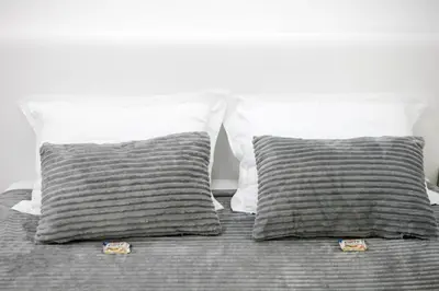 a bed with two gray pillows and two white pillows at Natalie's Studio in Belgrade