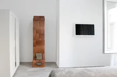 a bedroom with a bed and a tv on a wall at Natalie's Suite in Belgrade