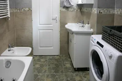 a bathroom with a washing machine and a sink at Natalie's Suite in Belgrade