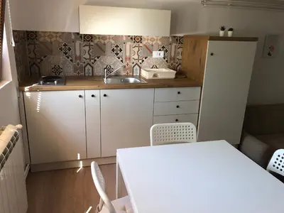 a small kitchen with a sink and a table at Small & Sweet Apartments in Belgrade