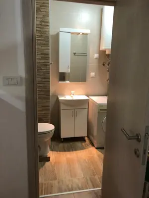 a bathroom with a toilet and a sink and a mirror at Small & Sweet Apartments in Belgrade