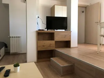 a living room with a television on a wooden entertainment center at Small & Sweet Apartments in Belgrade