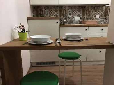 a kitchen with a counter with two bowls and a green stool at Small & Sweet Apartments in Belgrade