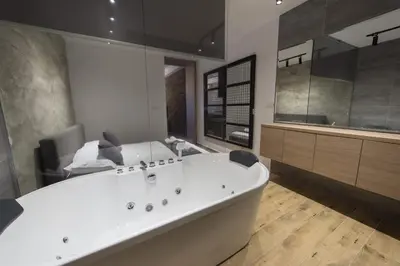 a large bathroom with a tub and a large mirror at Empire Luxury Apartments in Belgrade