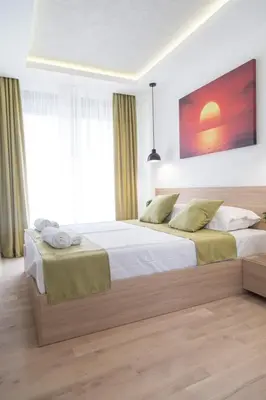 a bedroom with two beds and a painting on the wall at Empire Luxury Apartments in Belgrade
