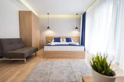 a bedroom with a bed and a chair at Empire Luxury Apartments in Belgrade