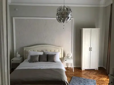 a bedroom with a large bed and a chandelier at Natalie's Residence in Belgrade
