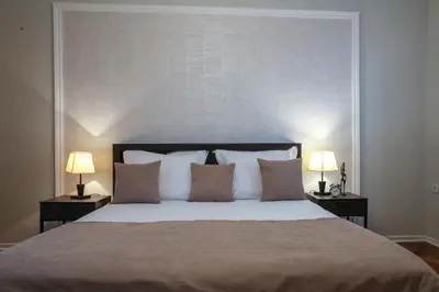 a bedroom with a large bed with two lamps at Natalie's Residence in Belgrade