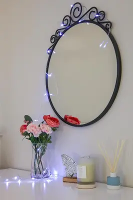 a table with a vase of flowers and a mirror at Natalie's Residence in Belgrade